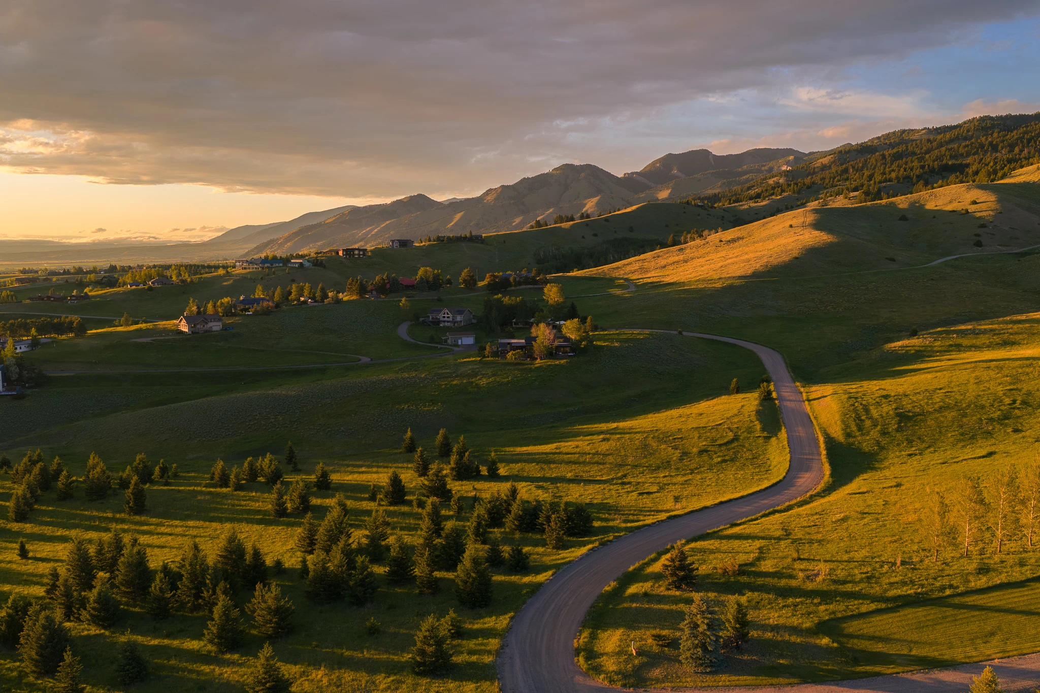Aerial view of a winding road through the valley at sunset — architectural photography Bozeman Montana, Living Places Design Studio